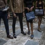Models pose for a photo holding leather handbags created by a Haitian designer, in Port-au-Prince, Haiti, Sunday, Sept. 26, 2021. (AP Photo/Rodrigo Abd)