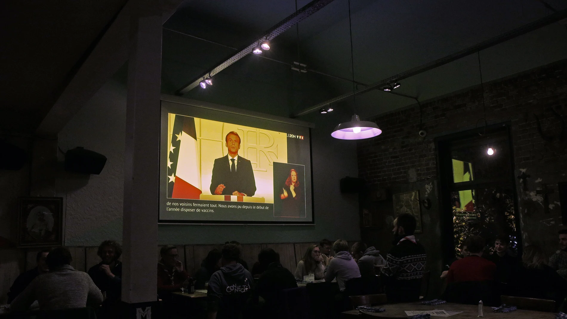 Los clientes de una bar de Lille escuchan el discurso del presidente Emmanuel Macron