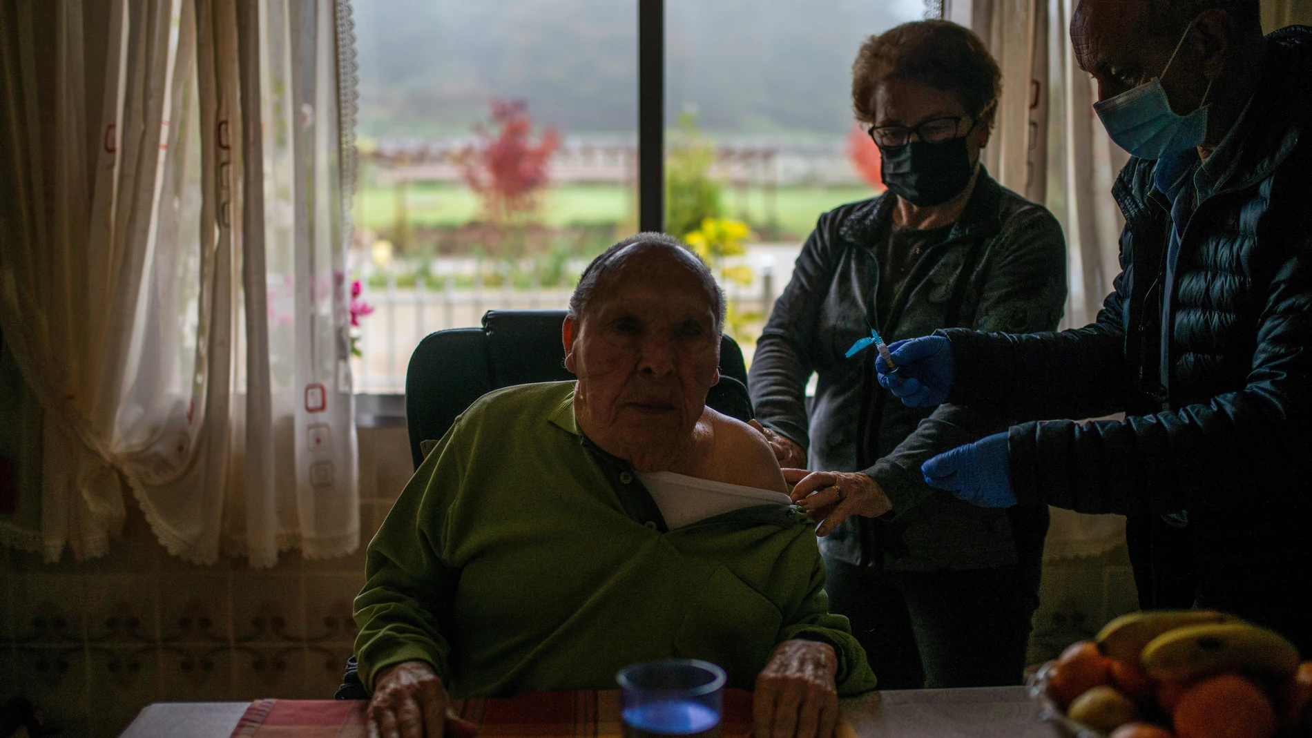 Un enfermero administra este jueves a un hombre la tercera dosis de la vacuna contra el coronavirus en un domicilio de Avión (Ourense)