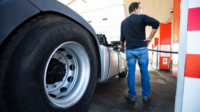 Un camionero echa carburante diésel a su camión