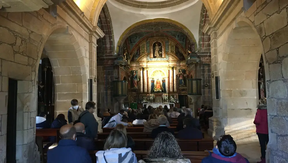 Interior del Santuario con los fieles rezando el rosario.