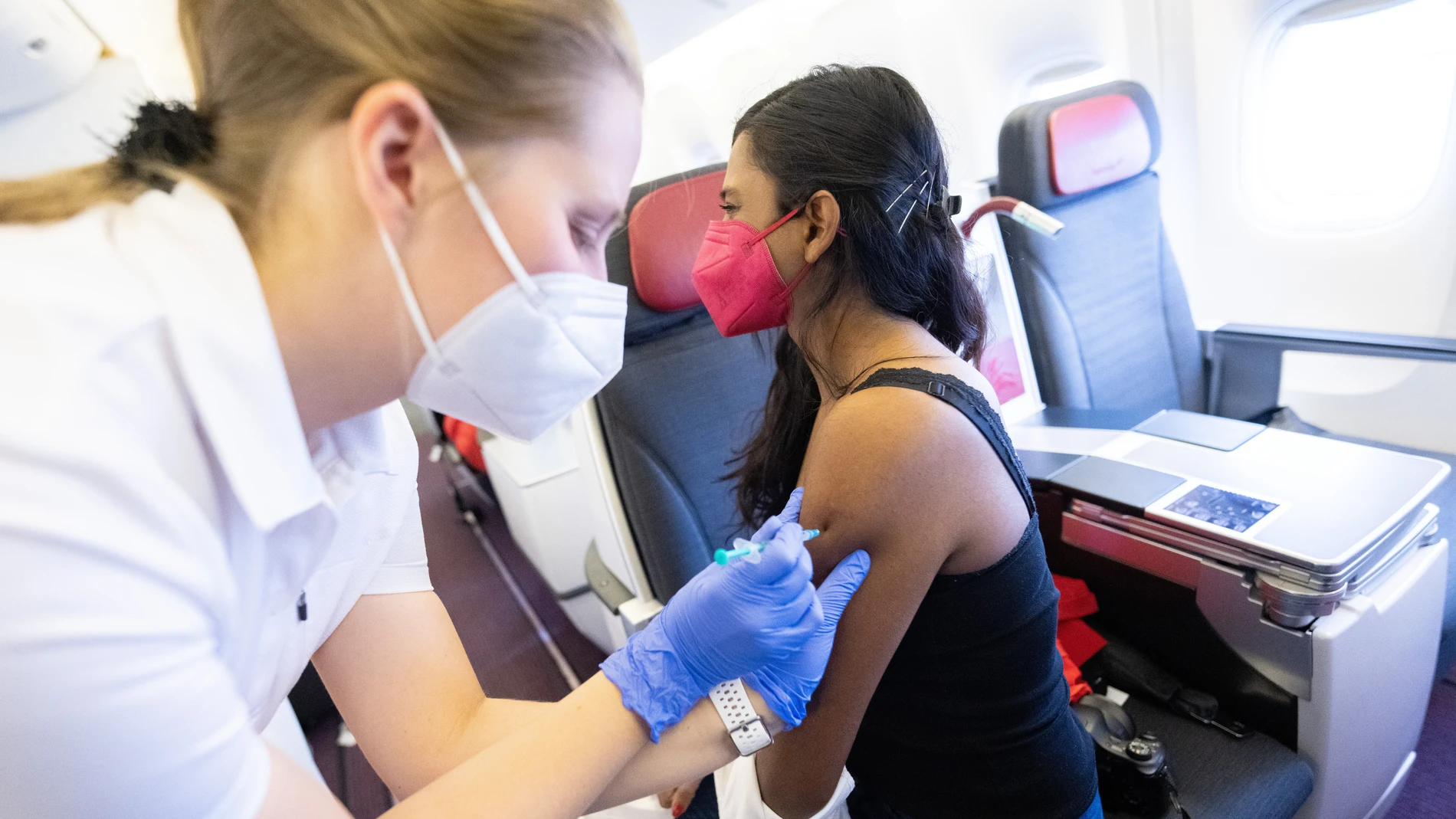 Una mujer se vacuna antes del confinamiento de los no vacunados dentro de un Boeing 777 durante una de las campañas para fomentar la vacunación en el aeropuerto de Viena