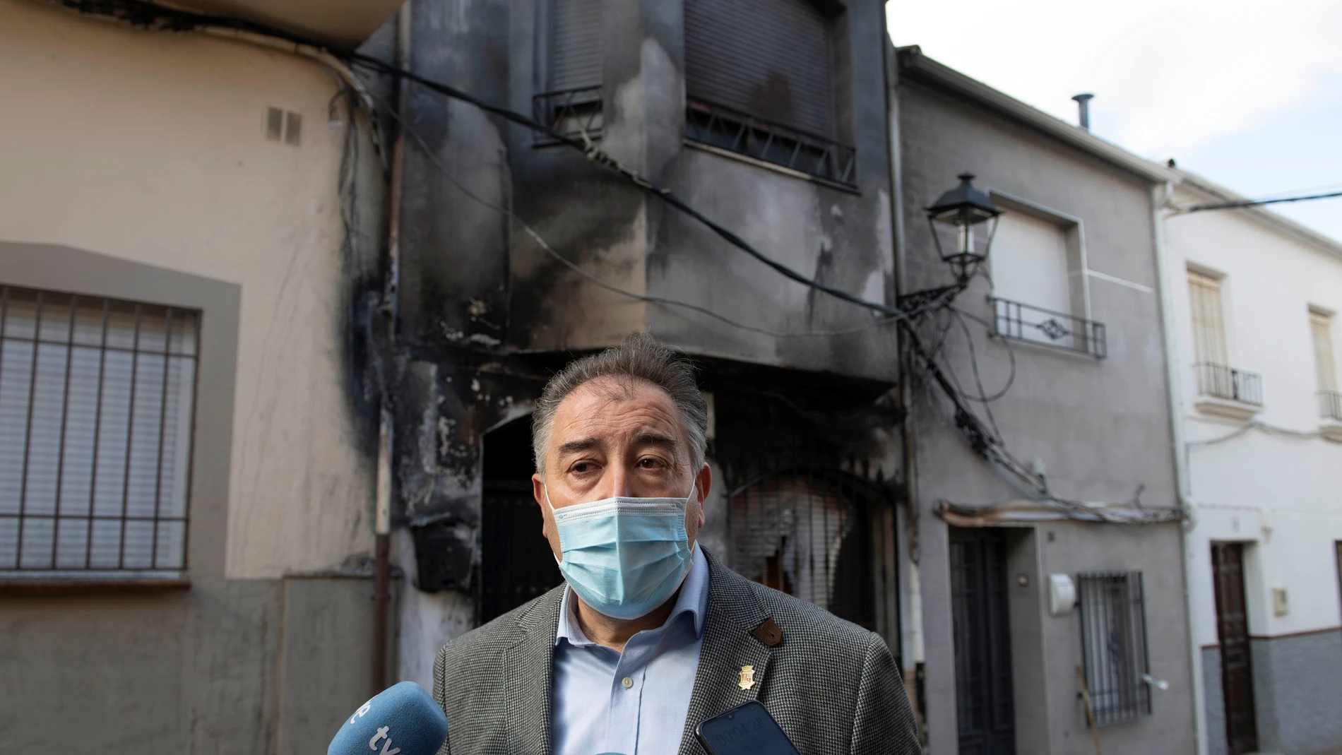 El alcalde de Navas de San Juan (Jaén), Joaquín Requena (PSOE), tras el incendio provocado por un grupo de personas con un contenedor en la fachada de su casa. EFE/ José Manuel Pedrosa