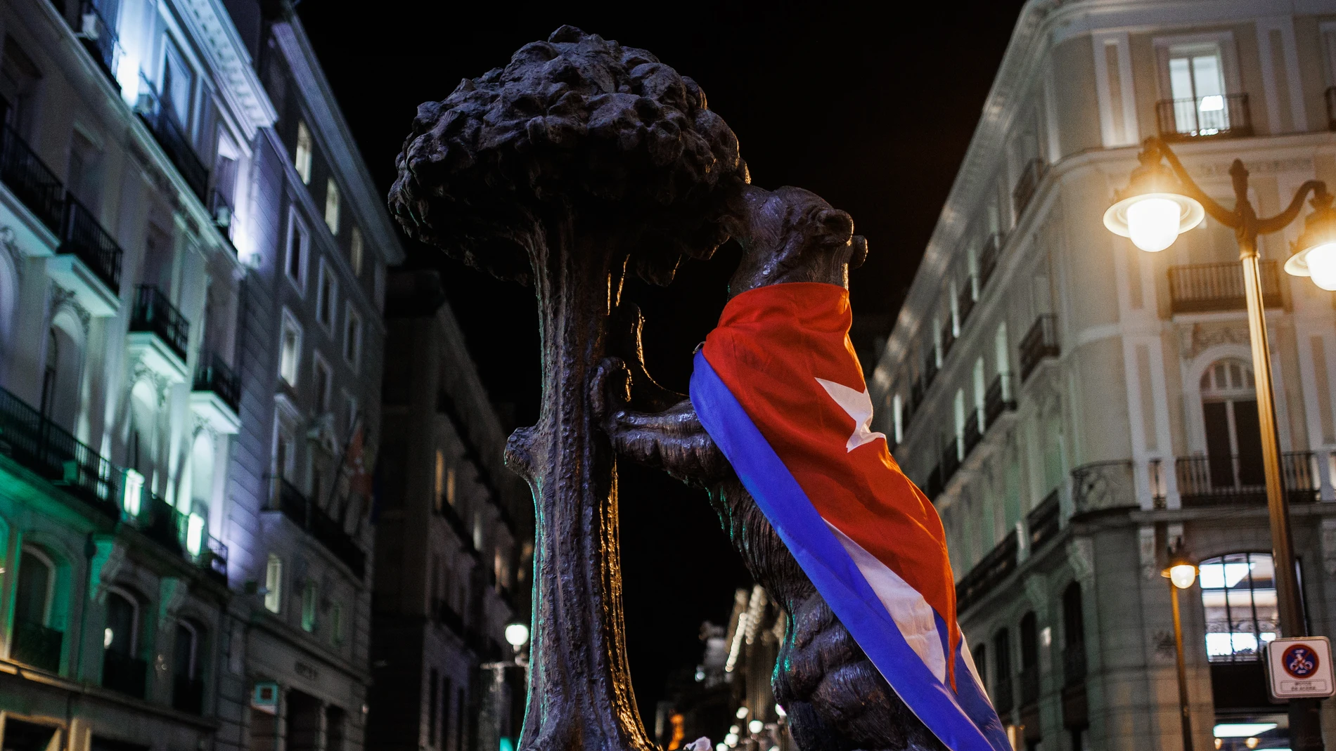 La estatua del oso y el madroño vestida con la bandera de Cuba en una concentración de apoyo a las marchas en Cuba contra las políticas del Gobierno de Miguel Díaz-Canel