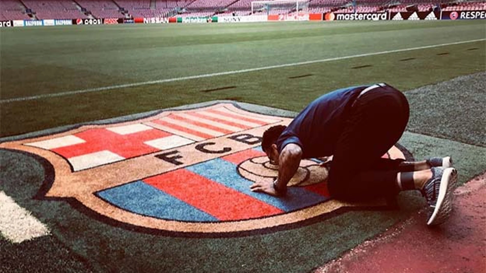 Dani Alves besa el escudo del Barcelona en el Camp Nou.