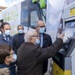 Manuel saca dinero junto a su bisnieto Óscar del cajero instalado en el bibliobús inaugurado hoy en Matilla de los Caños, en la imagen junto al presidente de la Diputación de Salamanca, Javier Iglesias