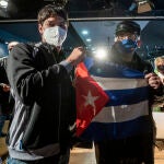 Yunior García Aguilera, impulsor del #15NCuba (i), posa con un hombre con una bandera de Cuba después de comparecer en rueda de prensa, en el Centro Cultural Galileo