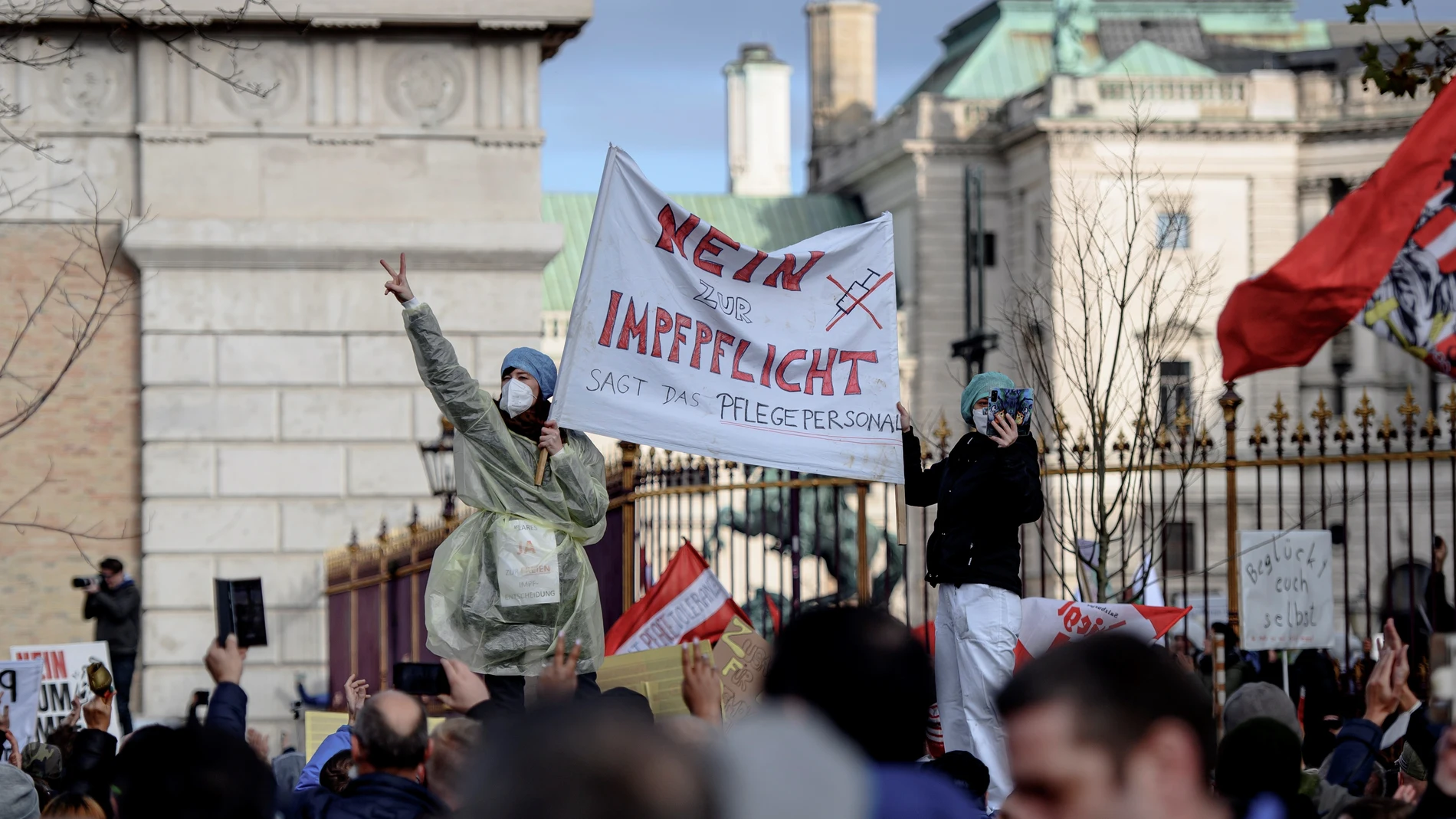 Manifestantes en una calle de Viena muestran una pancarta en la que puede leerse "El personal de enfermería dice no a la vacunación obligatoria"