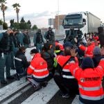 Trabajadores del metal cortando uno de los tramos de entrada al puerto de Algeciras (Cádiz) este lunes donde se han producido retenciones. EFE/ A.Carrasco Ragel