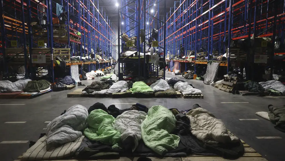 Migrantes duermen en un centro logístico en el puesto de control &quot;Kuznitsa&quot; en la frontera entre Bielorrusia y Polonia, cerca de Grodno, Bielorrusia