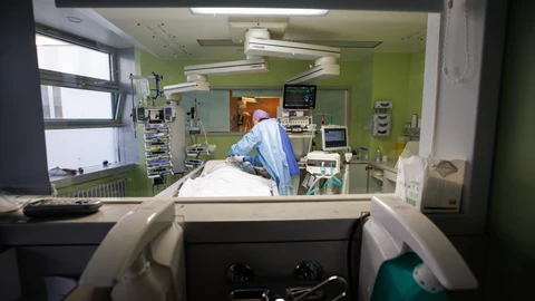 En la imagen, un sanitario atiende a un paciente de covid en la UCI