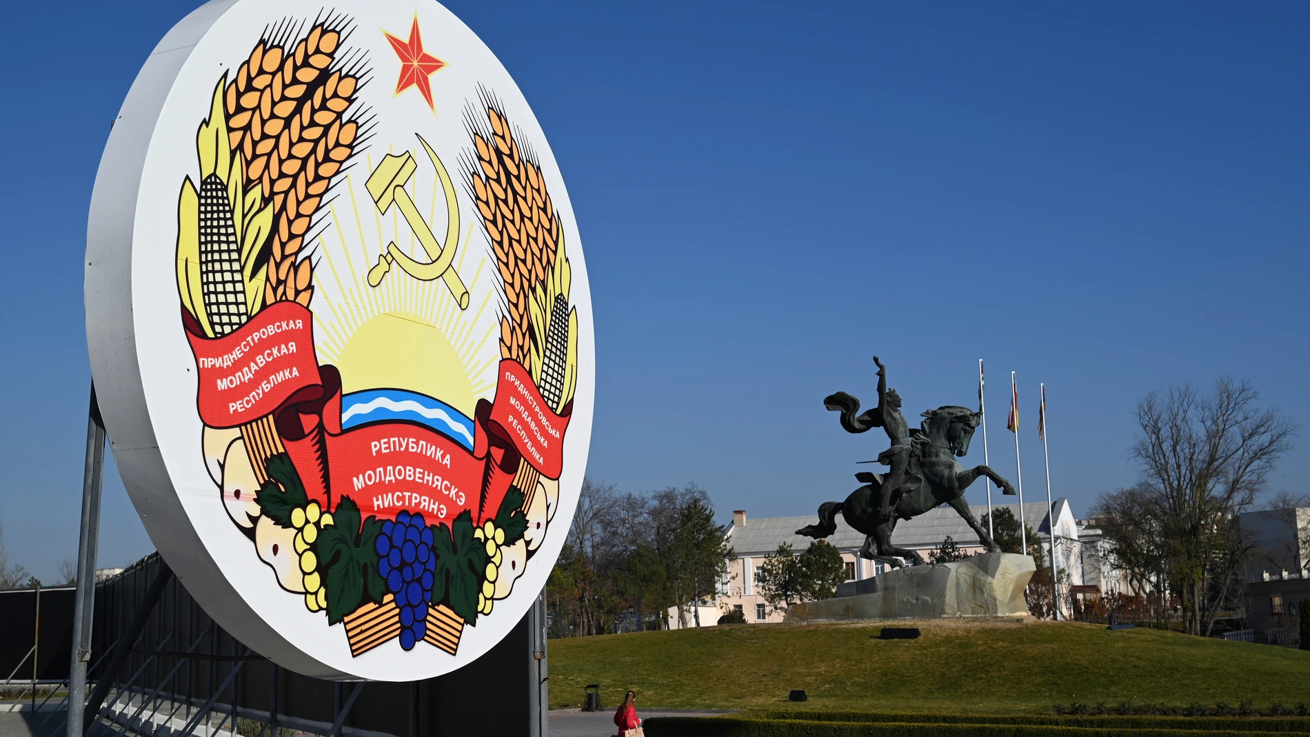 Imagen del escudo transnistrio y al fondo la estatua ecuestre de Alexandr Suvórov, el legendario general ruso que fundó Tiráspol, en la plaza central de la capital de la autoproclamada República de Transnistria