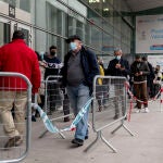 Varias personas hacen cola para la tercera dosis contra la covid en el Wizink Center, Madrid (España)