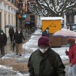 Un grupo de personas camina por una calle nevada en el centro de Soria