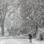 Un hombre pasea bajo la nieve caída en Valladolid