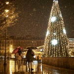 Varias personas caminan bajo la nieve en Pamplona.