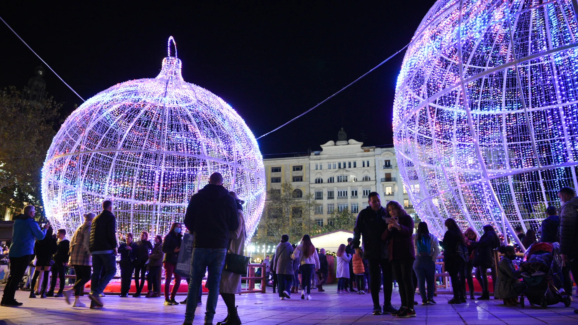 Un grupo de personas asiste al acto de encendido de la iluminación navideña de la plaza del Ayuntamiento en Valencia