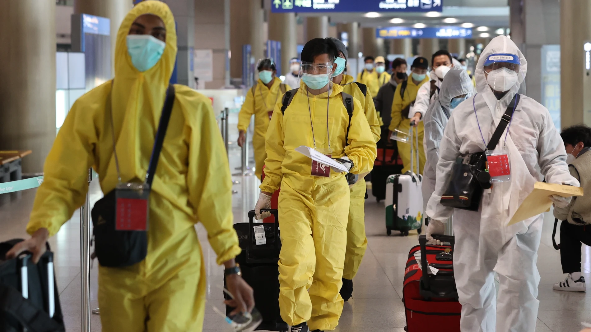 Pasajeros en el aeropuerto de Corea del Sur protegidos con trajes especiales por el coronavirus