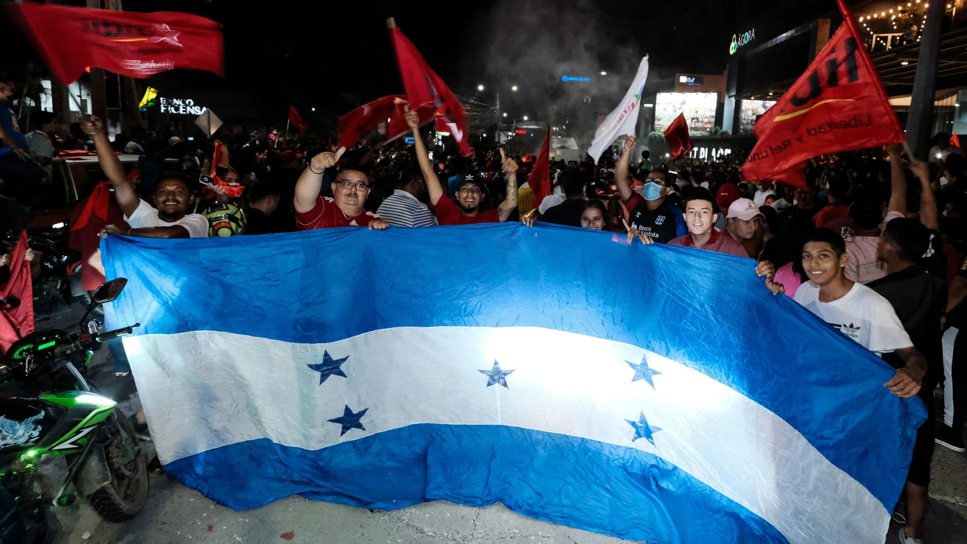 Supporters of the Liberty and Refoundation Party (LIBRE) hold an oversized flag of Honduras after the closing of the general election, in San Pedro Sula, Honduras November 28, 2021. Picture taken November 28, 2021. REUTERS/Yoseph Amaya
