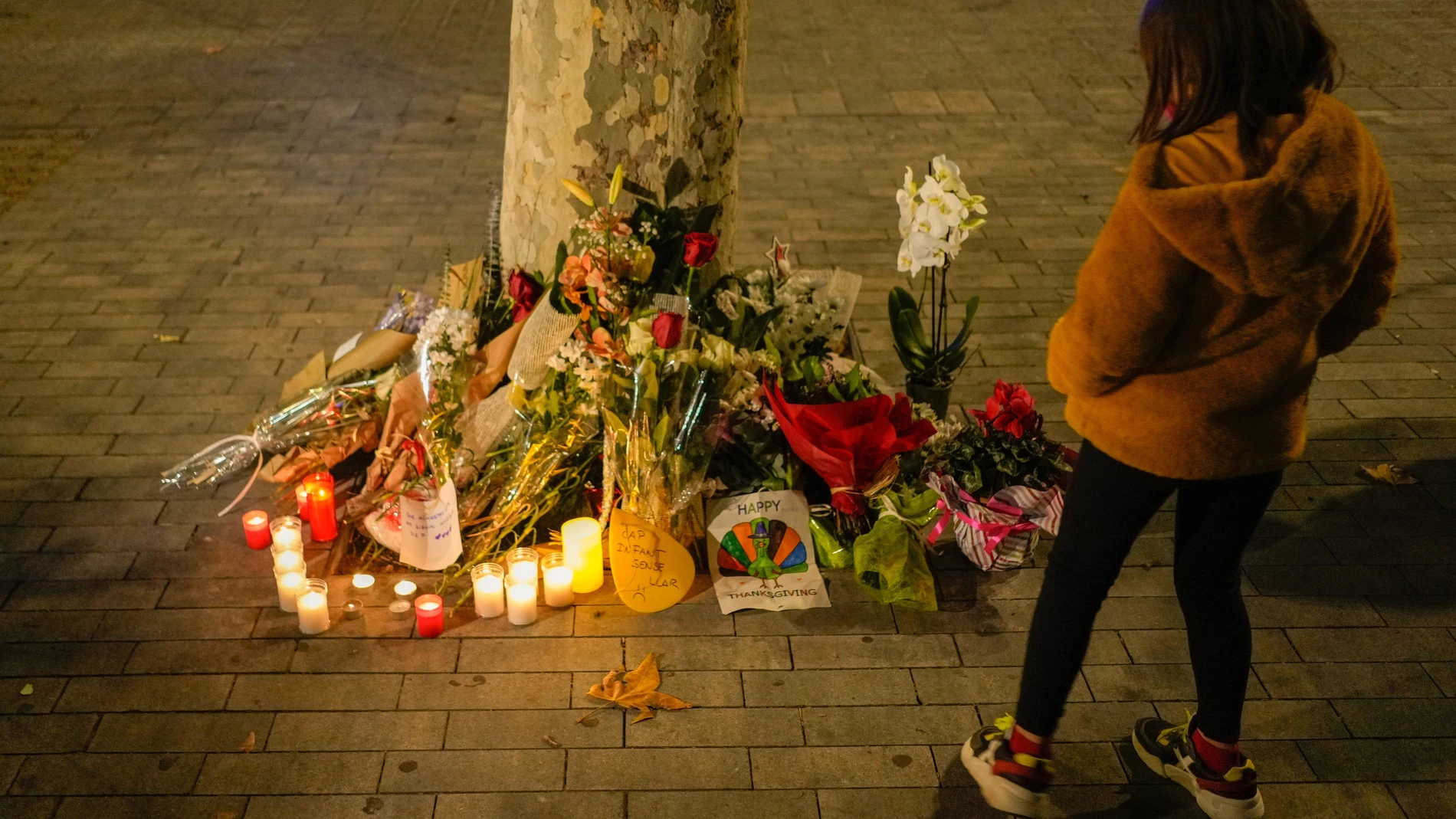 Flores y velas en memoria por las personas fallecidas en el incendio ocurrido en un local ocupado en la Plaza Tetuan de Barcelona