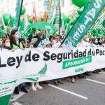 Un grupo de personas con una pancarta en la que se lee: `Ley de seguridad del paciente, aprobación ya!´, participa en una concentración de enfermeros, en la Plaza de las Cortes frente al Congreso de los Diputados