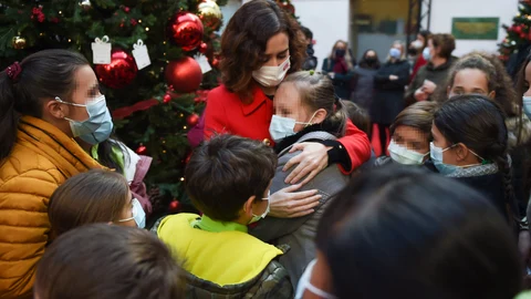 La presidenta de la Comunidad de Madrid, Isabel Díaz Ayuso, abraza a una niña en uno de los árboles del Bosque de los Deseos, ayer en Madrid