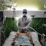 Un sanitario tras un paciente contagiado de Covid en Lyon, Francia