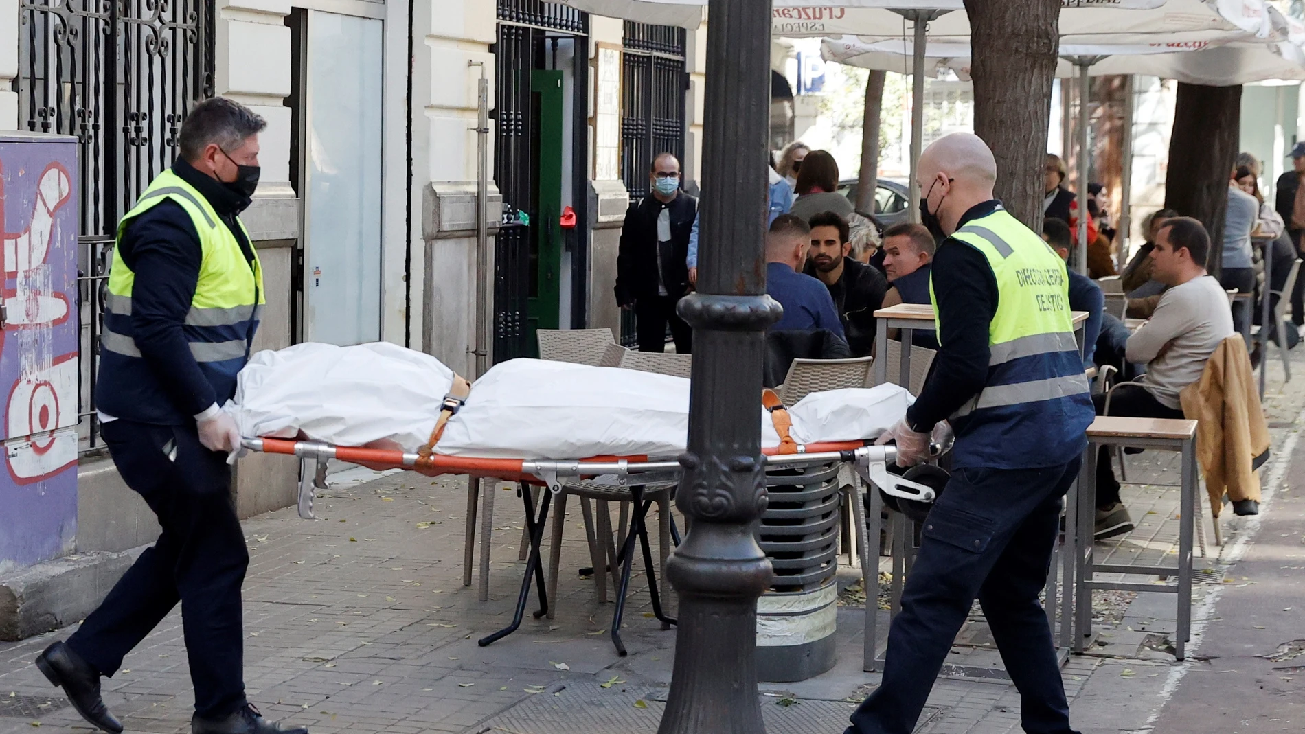 Operarios del retén fúnebre sacan el cadáver de mujer de 30 años de edad que ha sido encontrada este sábado en una vivienda de València asesinada presuntamente a manos de un hombre con el que mantenía una relación sentimental