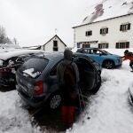 Dos personas empujan un vehículo atrapado en el parking de Roncesvalles tras las intensas nevadas que se han registrado estos días