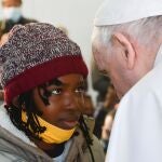 El Papa Francisco, ayer, saluda a una de las menores del campamento para refugiados de Moria