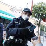 En la imagen, una agente solicita el pasaporte covid a un viajero de autobús en Brescia (Italia)