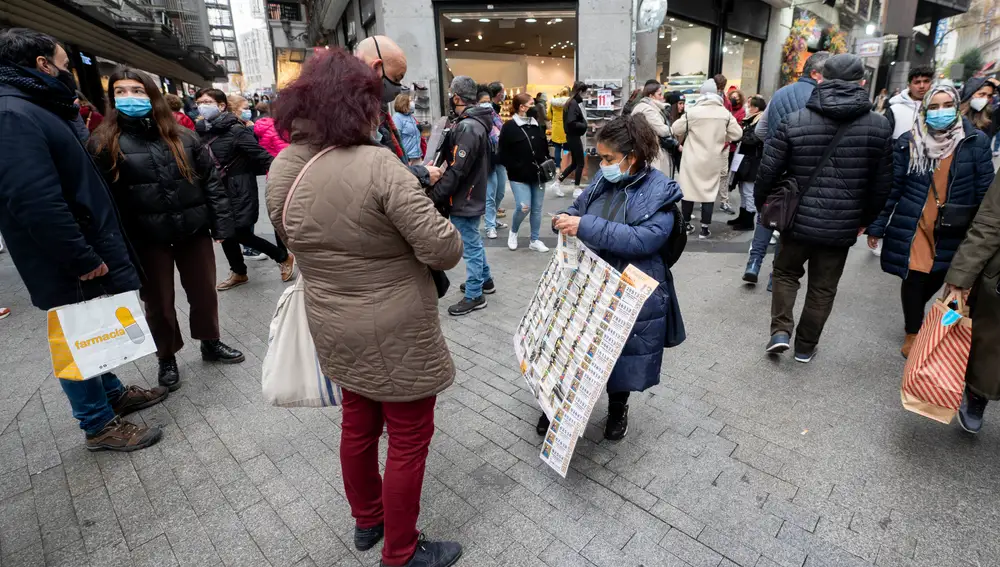 Una mujer compra un décimo de lotería de Navidad a una vendedora ambulante en Madrid | Fuente: Alberto Ortega / Europa Press