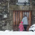 Dos personas entran por la puerta de un domicilio en Lugo, Galicia, (España)
