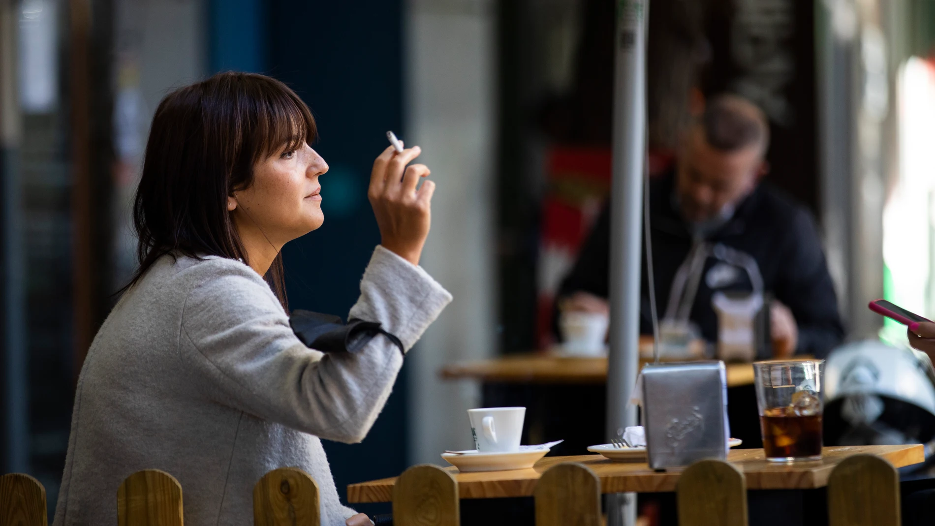 Imagen de una mujer fumando en una terraza de un bar en Madrid.