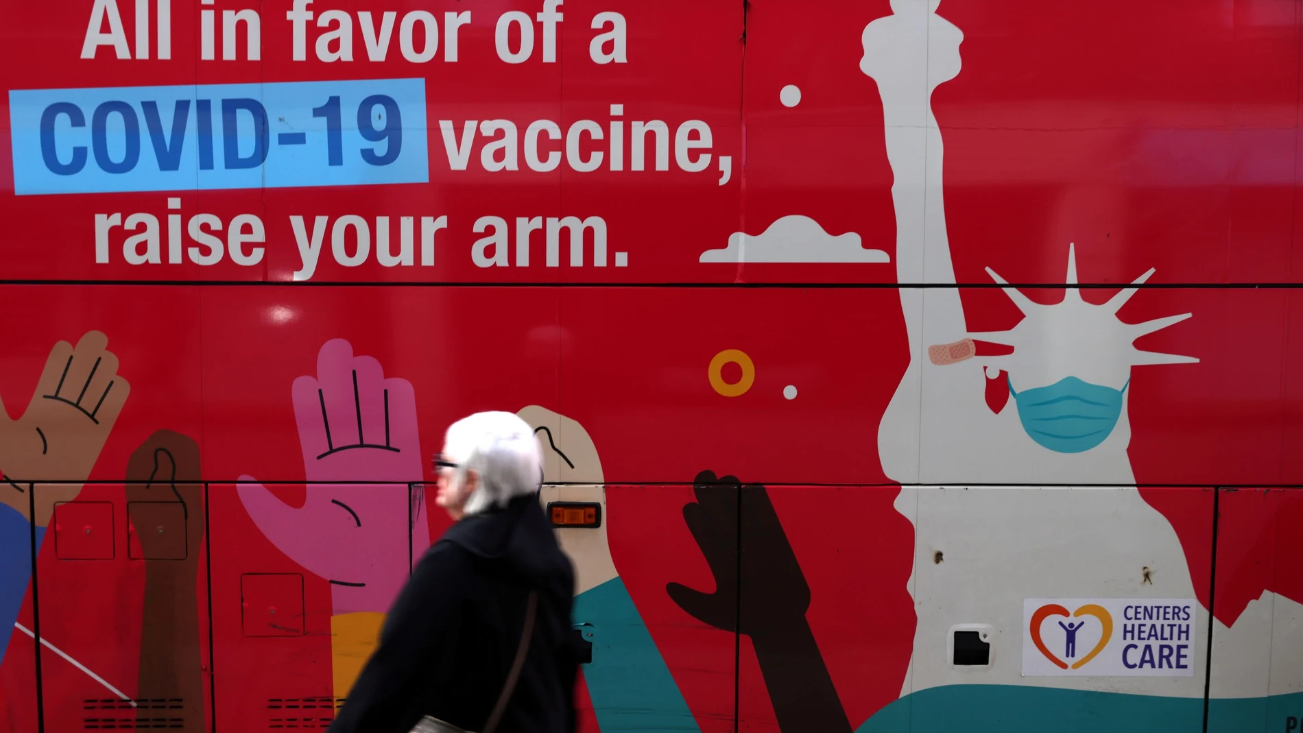Una mujer pasa junto a una clínica de vacunación móvil en Manhattan