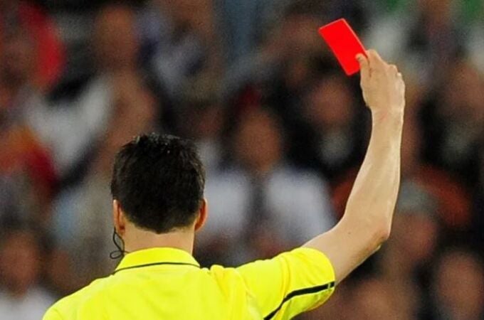 Un árbitro muestra una tarjeta roja