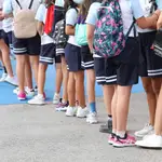 Un grupo de niños esperan a entrar en un colegio de Primaria.