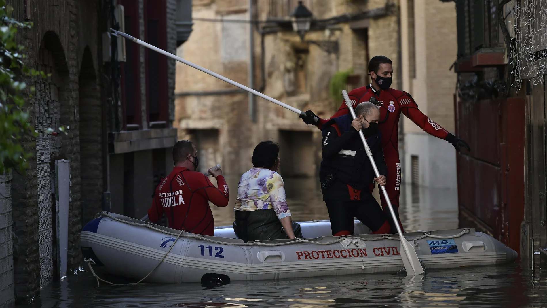 El equipo de rescate transporta a una mujer desde su casa en una zona inundada cerca del río Ebro en Tudela