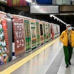 MADRID, 13/12/2021.- Varias personas caminan junto al tren de la línea 6 de metro de Madrid decorado con motivos navideños. EFE/ Fernando Villar