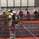 Firefighters use a crane to rescue people lined up on a roof after a fire broke out at the World Trade Centre in Hong Kong, China, December 15, 2021 in this still image obtained from a social media video. Wing Shun Kwok/via REUTERS THIS IMAGE HAS BEEN SUPPLIED BY A THIRD PARTY. MANDATORY CREDIT.