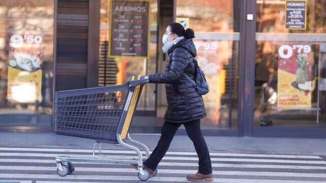 Una mujer camina con un carrito de un supermercado en Madrid