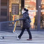 Una mujer camina con un carrito de un supermercado en Madrid