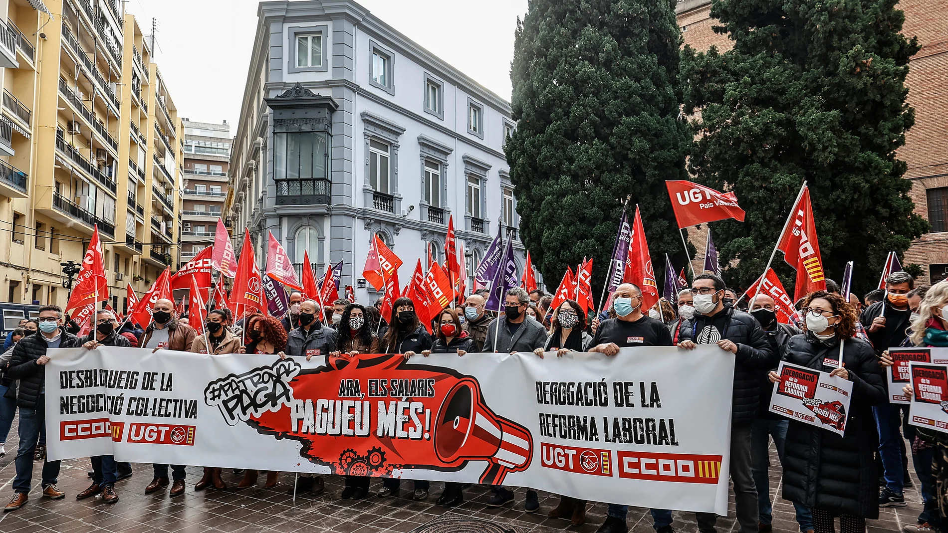 Un grupo de personas con una pancarta participa en la concentración en la Comunidad Valenciana, frente a la sede de la Confederación Empresarial