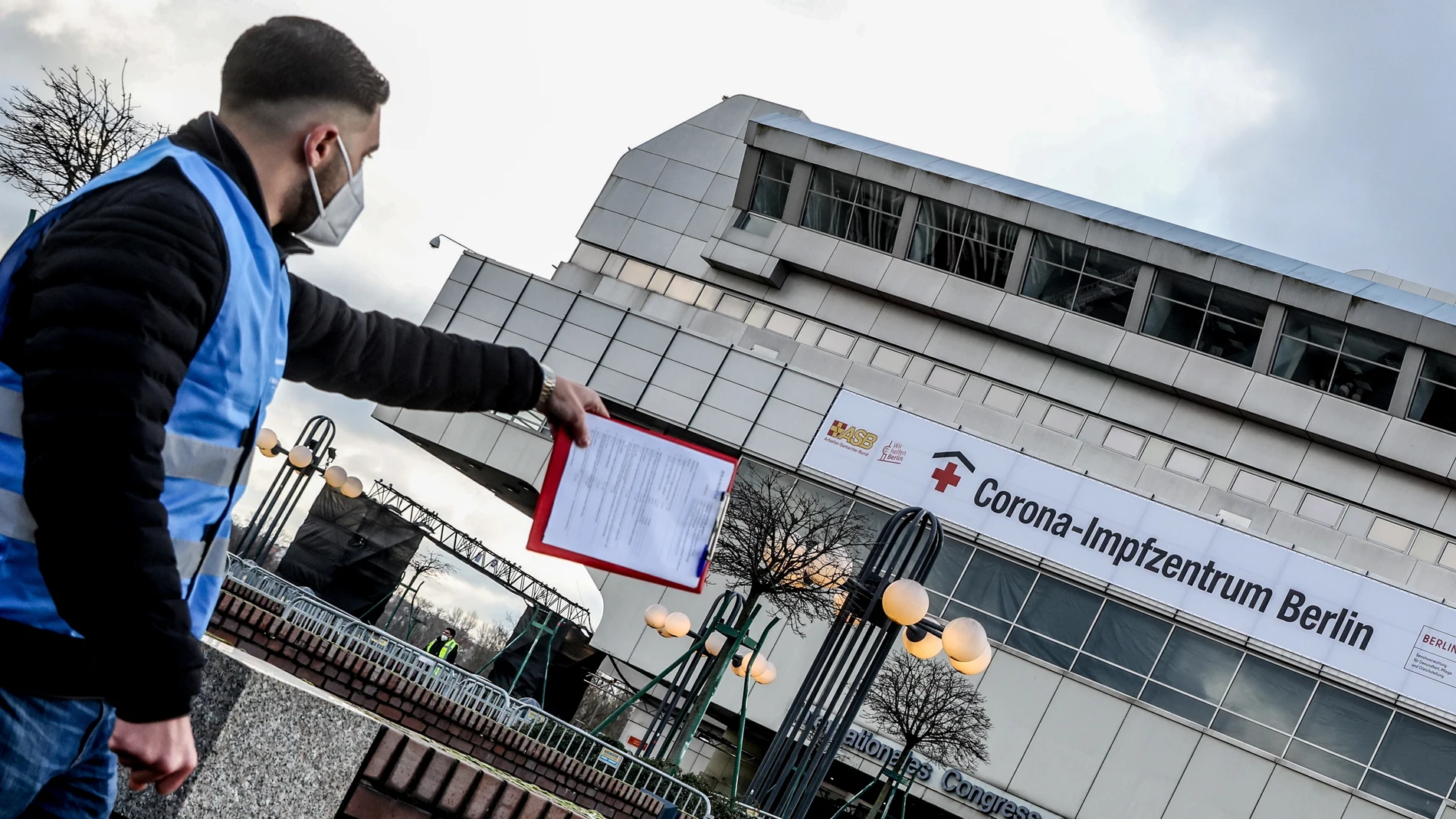 Un trabajador señala un punto de vacunación en Berlín, Alemania