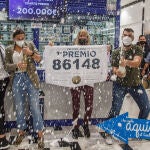 Empleados de la administración situada en el centro comercial El Mirador de las Palmas de Gran Canaria celebran con varios agraciados que han vendido parte del número 86148 correspondiente al 'Gordo' del Sorteo Extraordinario de la Lotería de Navidad