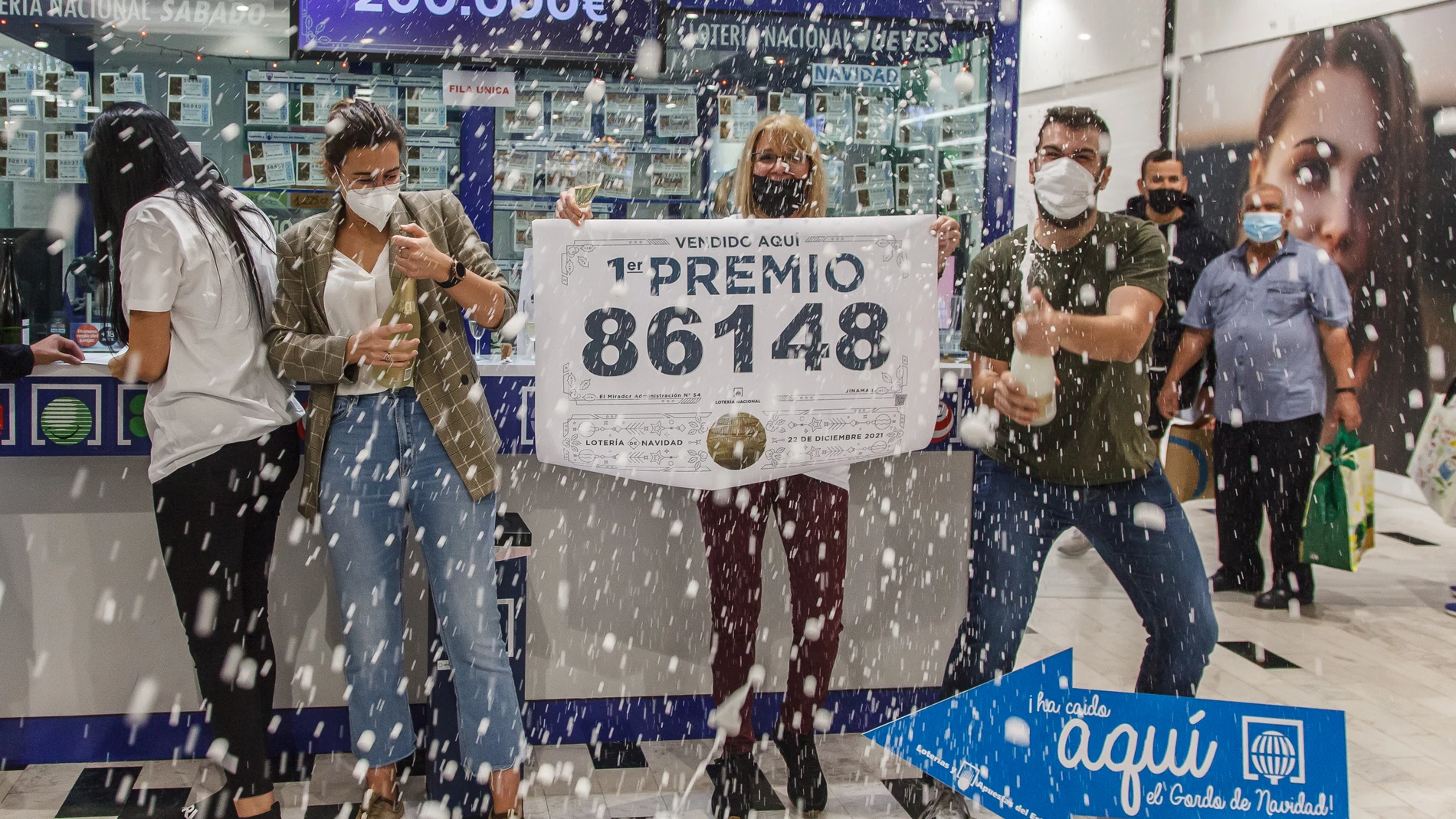 Empleados de la administración situada en el centro comercial El Mirador de las Palmas de Gran Canaria celebran con varios agraciados que han vendido parte del número 86148 correspondiente al 'Gordo' del Sorteo Extraordinario de la Lotería de Navidad