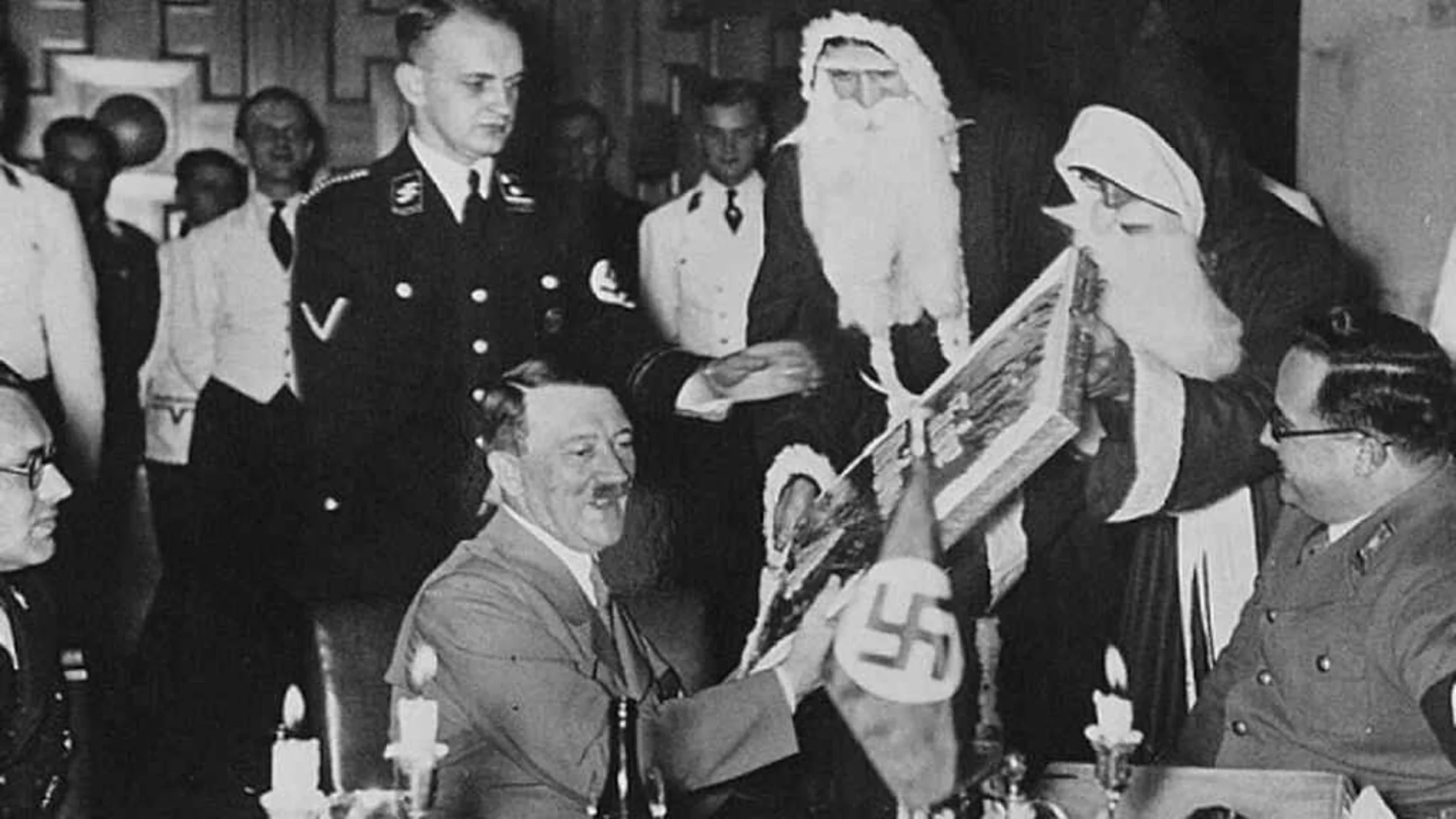 Adolf Hitler y dos nazis disfrazados de Papá Noel durante una cena de Navidad