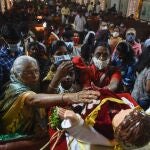 Feligreses cristianos indios tocan una figura del Niño Jesús durante la misa del día de Navidad en la basílica catedral de Santhome (santo Tomás)en Chennai, en la India, este sábado, 25 de diciembre