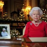 In this undated photo issued on Thursday Dec. 23, 2021, Britain's Queen Elizabeth II records her annual Christmas broadcast in Windsor Castle, Windsor, England. The photograph at left shows The Queen and Prince Philip taken in 2007 at Broadlands to mark their Diamond wedding anniversary. (Victoria Jones/Pool via AP)