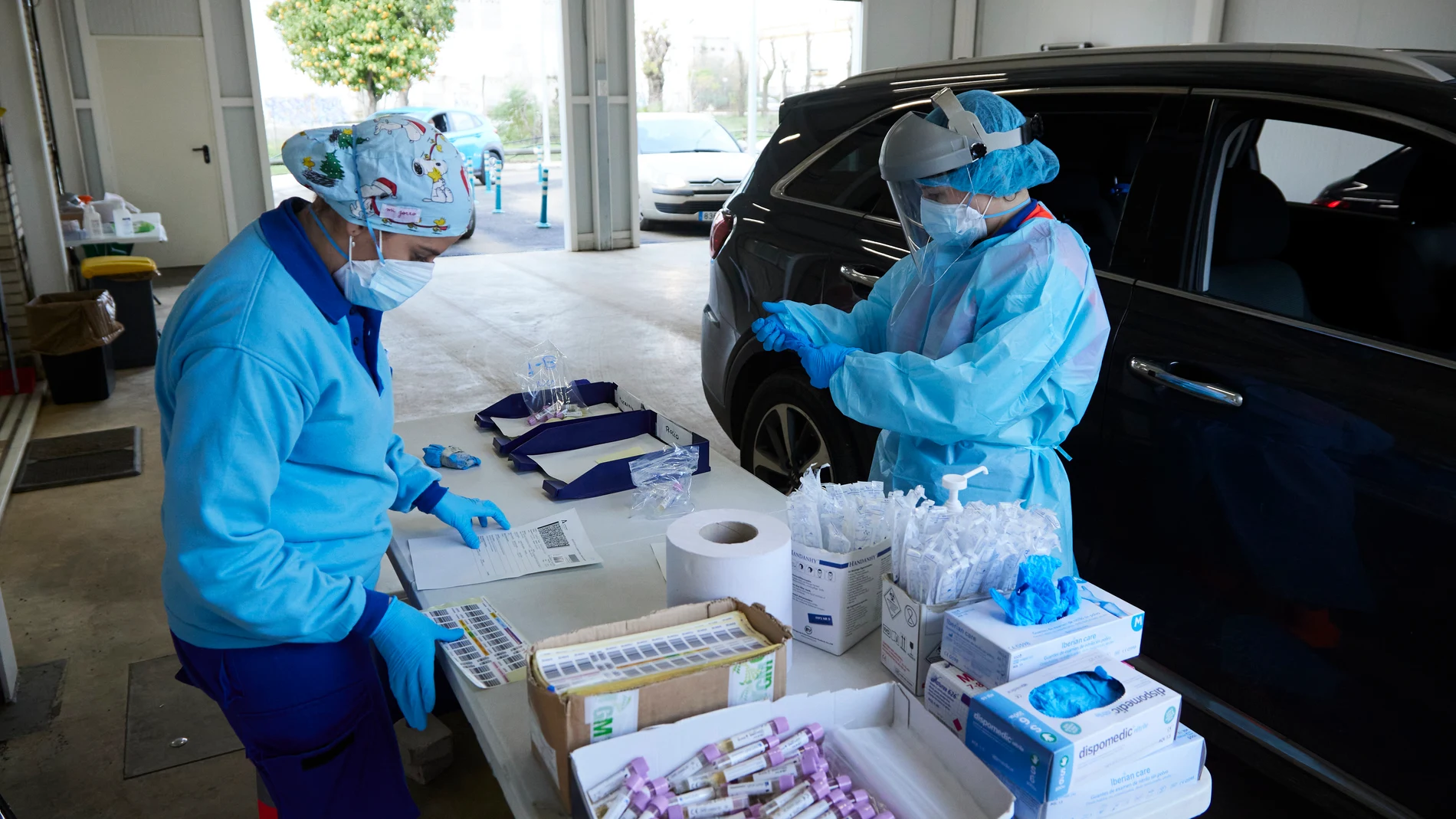 Dos enfermeras preparan el test en una mesa durante la realización de PCR en el autocovid instalado en el Hospital Militar en Sevilla